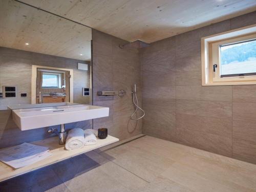 uma grande casa de banho com um lavatório e um chuveiro em Haus Motta em Gaschurn