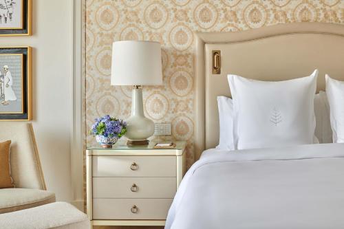 a bedroom with a bed and a lamp and a chair at Four Seasons Hotel Cairo at Nile Plaza in Cairo
