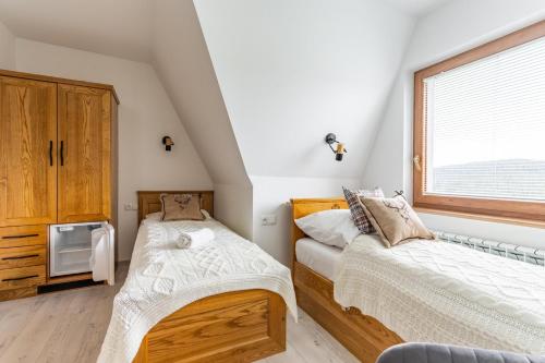 a bedroom with two beds and a window at Noclegi Siuster - komfortowe pokoje z widokiem na góry - doskonała lokalizacja, niedaleko Term Bukovina in Bukowina Tatrzańska