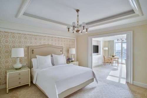 a bedroom with a white bed and a chandelier at Four Seasons Hotel Cairo at Nile Plaza in Cairo