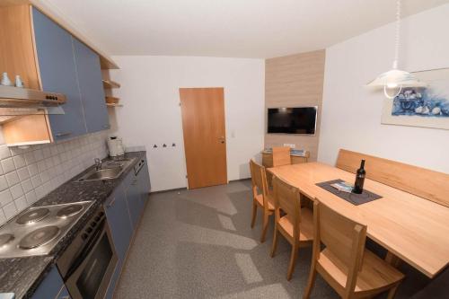 a kitchen with a table and a kitchen with blue cabinets at Appartement Montanea in Schruns-Tschagguns