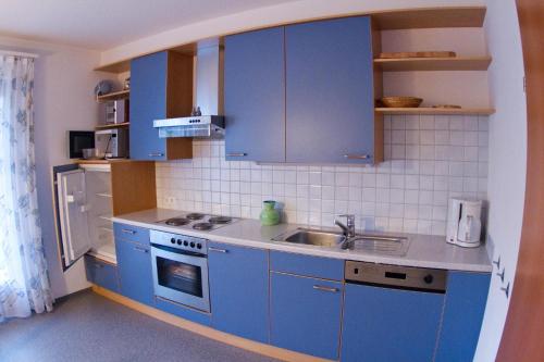 a kitchen with blue cabinets and a sink at Appartement Montanea in Schruns-Tschagguns