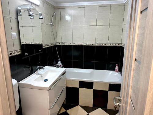 een badkamer met een bad, een wastafel en een toilet bij ROYAL APARTMENT in Buzău