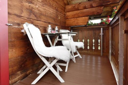 a room with two white chairs and a table at Ferienwohnung Frömlig in Silbertal