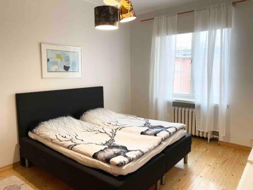 ein Schlafzimmer mit einem Bett in einem Zimmer mit einem Fenster in der Unterkunft ULLANLINNA Big apartment in the heart of Helsinki in Helsinki