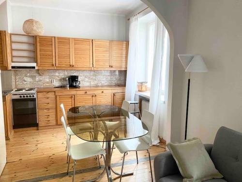 cocina con mesa de cristal y sillas en una habitación en ULLANLINNA Big apartment in the heart of Helsinki, en Helsinki