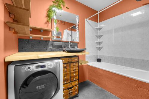 ein Badezimmer mit einer Waschmaschine und einer Badewanne in der Unterkunft L'Hippocrate - Charmant appartement avec terrasse in Toulouse