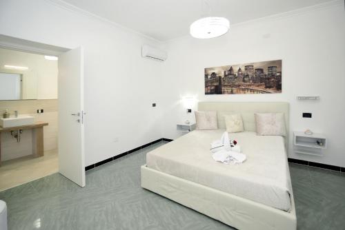 - une chambre blanche avec un lit blanc et un lavabo dans l'établissement Vacanze Top, à Peschici