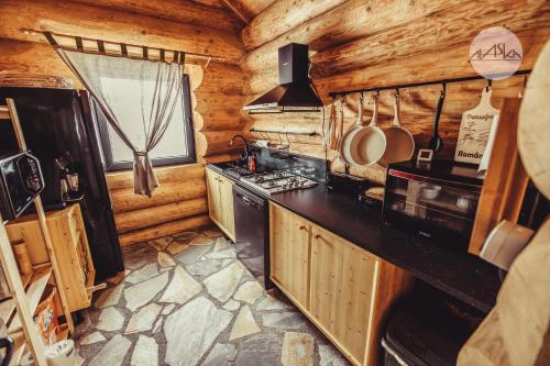 una cocina en una cabaña de madera con fogones en Cabana Alaska, en Ranca