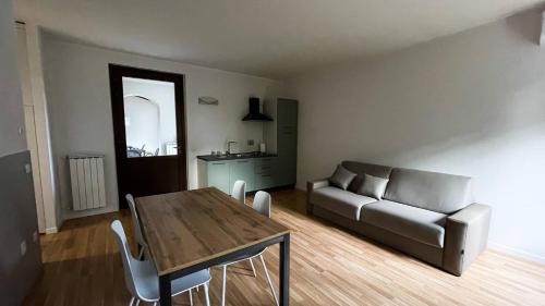 ein Wohnzimmer mit einem Tisch und einem Sofa in der Unterkunft AGRITURISMO LA CORTE DEI CAVALIERI in Montefalco