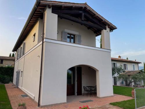 a white building with an archway in a yard at AGRITURISMO LA CORTE DEI CAVALIERI in Montefalco
