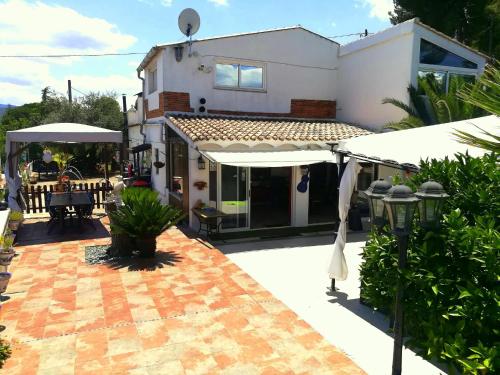 a house with an outdoor patio with umbrellas at La Rustika Ontinyent in Ontinyent