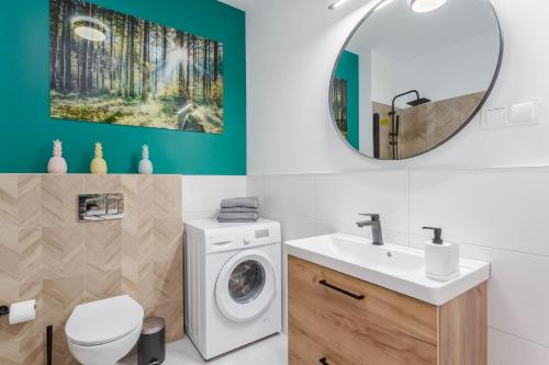 a bathroom with a washing machine and a mirror at Chill Apartments Warszawa Piaseczno in Józefosław