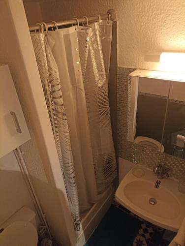une salle de bain avec un rideau de douche et un lavabo dans l'établissement Port Leucate Appartement 6 Voyageurs - 150 m de la plage, à Leucate
