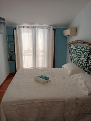 a bed with a towel on it with a window at Casa vacanze da CLARA in Castrovillari