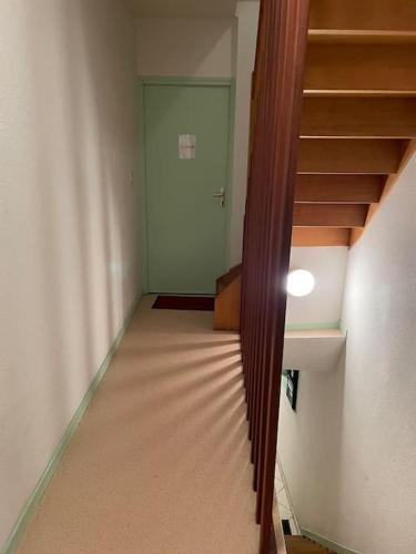 un couloir vide avec des escaliers dans une maison dans l'établissement Appartement COSY rue Chaussée, à Verdun-sur-Meuse