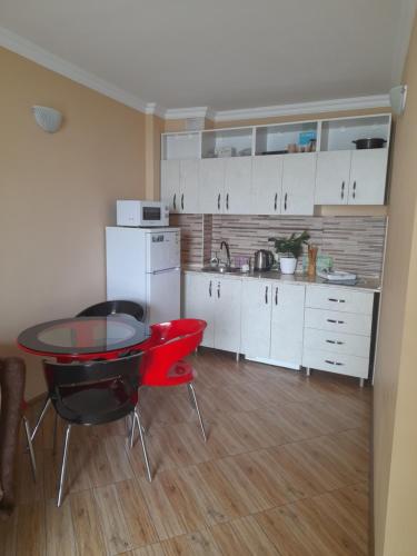 a kitchen with a table and chairs in a room at Apartment Orbi Plaza Batumi in Batumi