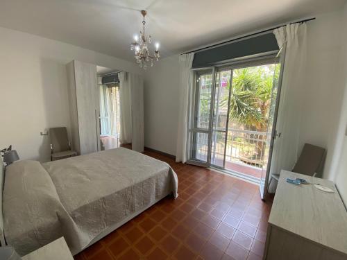 1 dormitorio con cama y ventana grande en Delizioso Bilocale ad Albenga con Terrazzo Vista Mare, en Albenga