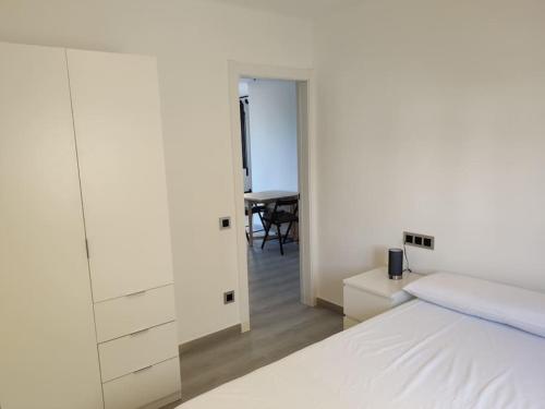a bedroom with a white bed and a table at CHARMING APARTMENT IN CALDETES in Caldes d'Estrac