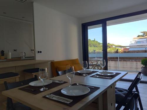 a table with wine glasses and a view of the ocean at CHARMING APARTMENT IN CALDETES in Caldes d'Estrac