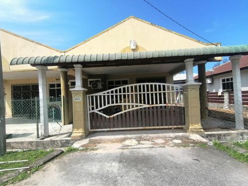 a porch with a wooden gate in front of a house at Promenade Homestay 2 in Kampong Sura Masjid