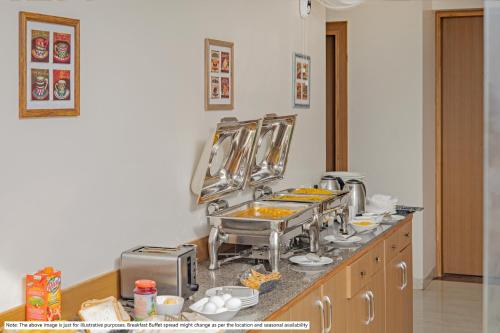 a kitchen with a counter with food on it at Treebo Atithi Bhavan, 1 Km From Ooty Lake in Ooty