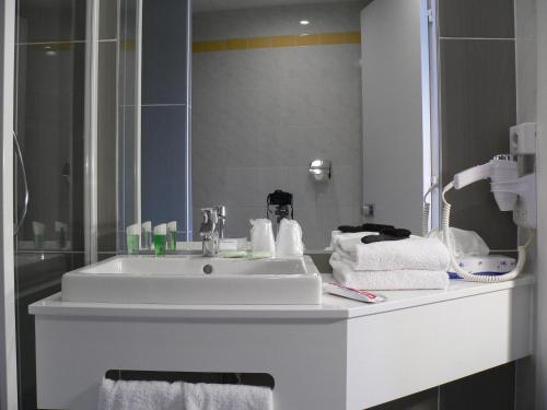a bathroom with a white sink and a mirror at Hotel Moderne in Arras