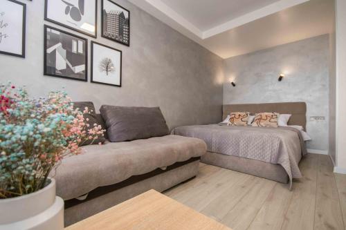 a bedroom with two beds and a couch at MYFREEDOM Апартаменти метро Оболонь in Kyiv