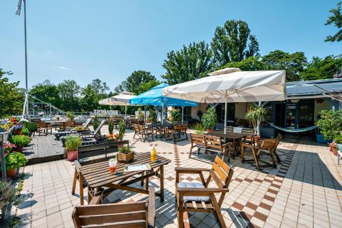 an outdoor patio with tables and chairs and umbrellas at Island Hostel Budapest in Budapest