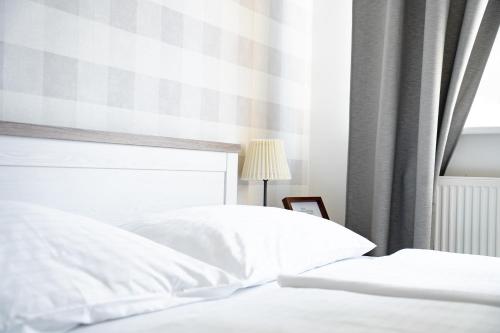 a bedroom with two white beds and a window at Hotel Arko in Prague