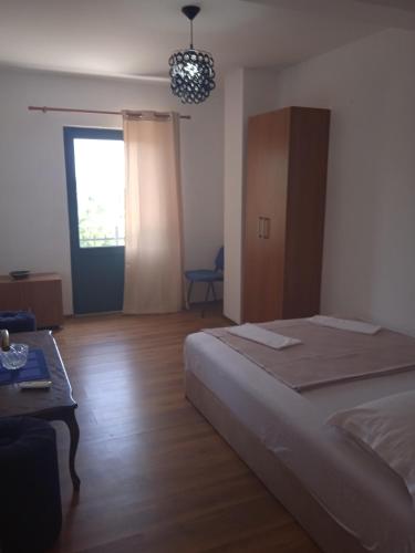 a bedroom with a bed and a table and a window at Villa Elena Zagora in Neodi