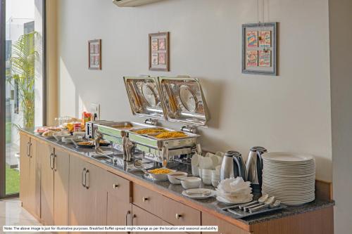 a buffet line with plates and food on it at Treebo Orion Sapphire, Beck Bagan in Kolkata