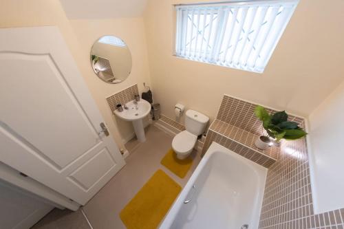 een badkamer met een bad, een toilet en een wastafel bij Manhattan Hideaway Warrington in Burtonwood