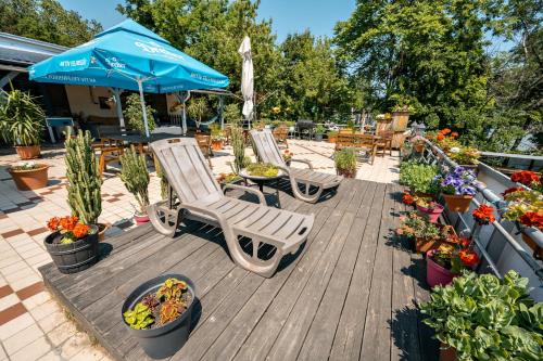 a deck with two chairs and an umbrella and potted plants at Island Hostel Budapest in Budapest