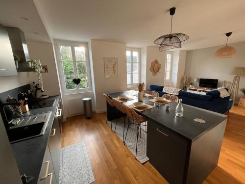 een keuken en een woonkamer met een tafel en een bank bij La Maison Pinot Noir in Gevrey-Chambertin