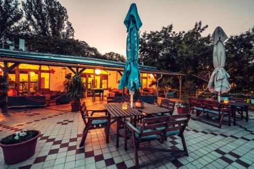 a patio with a table with umbrellas and chairs at Island Hostel Budapest in Budapest