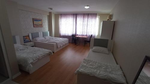 Habitación con 2 camas y mesa. en ESEN OTEL, en Antalya