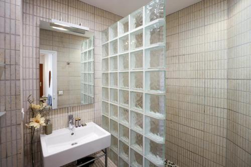 une salle de bain avec un lavabo et un miroir dans l'établissement Escalier d'Or ConciergerieDameCarcas, à Carcassonne