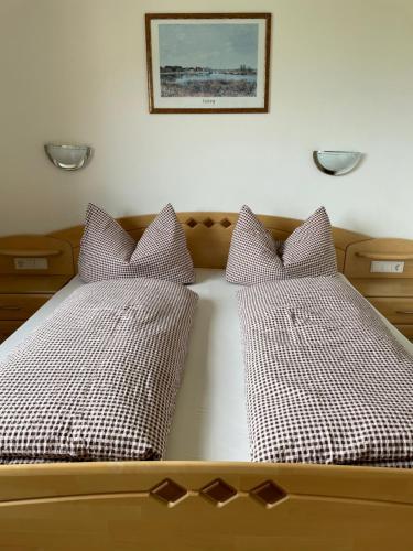 2 camas con almohadas a cuadros en un dormitorio en Ferienwohnung Halder, en Neustift im Stubaital