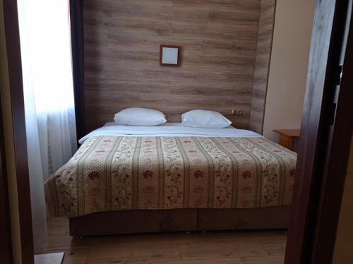 a bedroom with a bed with a wooden wall at Hotel LUDMIR in Volodymyr-Volynsʼkyy