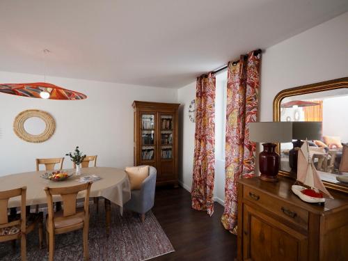 une salle à manger avec une table et un miroir dans l'établissement Emplacement de rêve, Maison à 20m des Plage, à Plouhinec