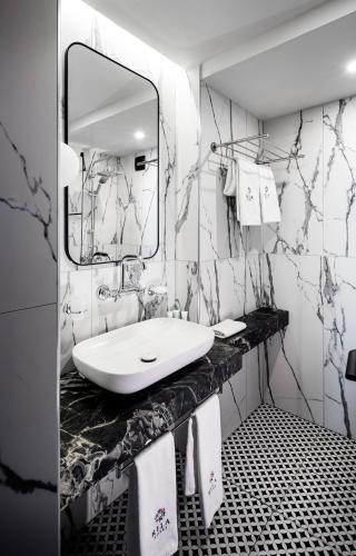 a black and white bathroom with a sink and a mirror at Rila Hotel Sofia in Sofia