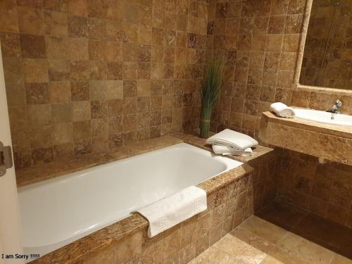 uma casa de banho com uma banheira e um lavatório em Royal Apartment 2 /freeWiFi,sharedpool,freeparking em Málaga