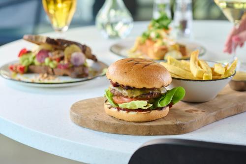 a sandwich on a cutting board with fries on a table at Cityden BoLo District in Amsterdam