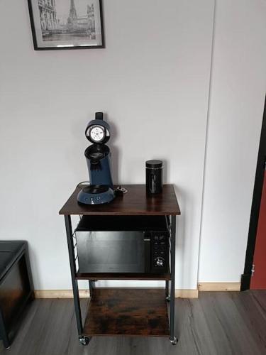 a table with a clock on top of a microwave at Studio Laly in Le Tréport