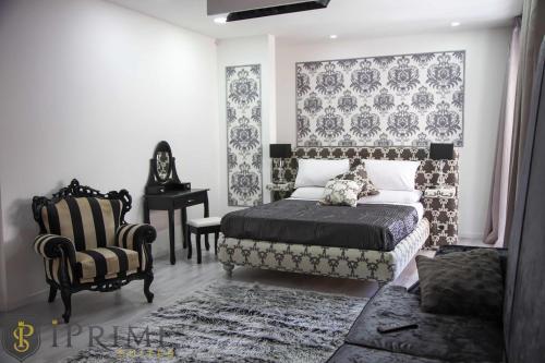 a bedroom with a bed and a chair and a table at Sliema Central Iprime Suites in Sliema