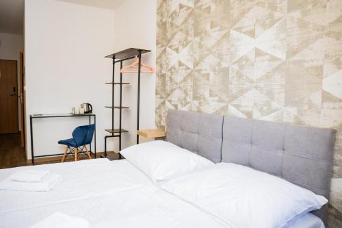 a bedroom with a white bed and a blue chair at Hotel Arko in Prague