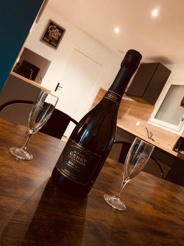 - une bouteille de vin assise sur une table avec 2 verres à vin dans l'établissement Villa Alba, à Auménancourt-le-Petit