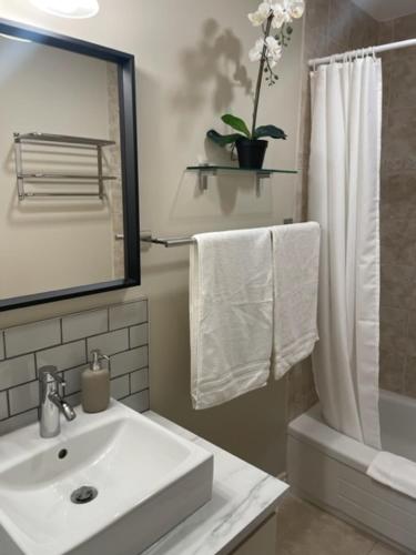 a white bathroom with a sink and a shower at Market Place Living in Stratford