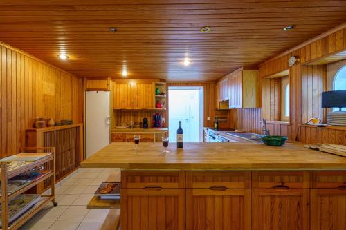 uma cozinha com armários de madeira e um frigorífico branco em Le Huic - Maison pour 9 avec jardin proche plage em Bénodet